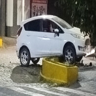Carro fica suspendo em canteiro ap&oacute;s colis&atilde;o contra moto no centro comercial de Corumb&aacute;