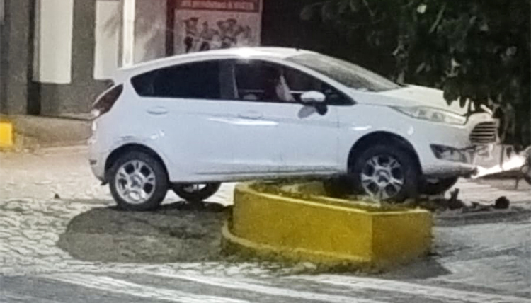 Carro fica suspendo em canteiro ap&oacute;s colis&atilde;o contra moto no centro comercial de Corumb&aacute;